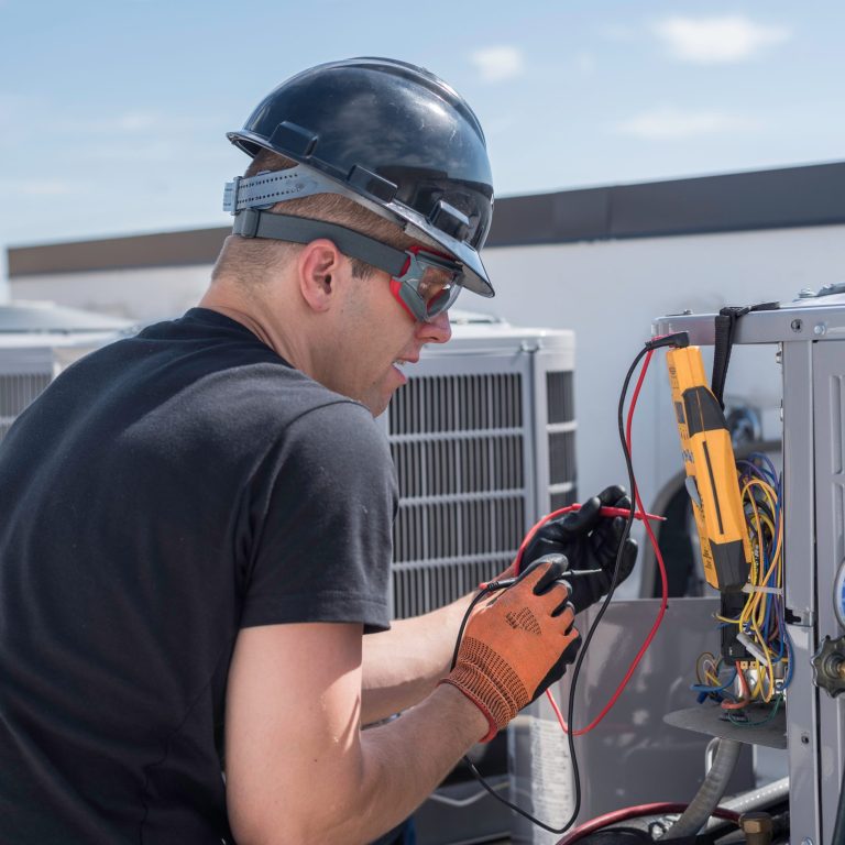 HVAC technician working on condensing unit electrical hvac contractors