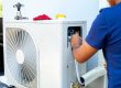 Male technician installing outdoor unit of air conditioner