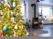 Festive interior of house is decorated for Christmas and New Year in loft style with black stove, fireplace, Christmas tree