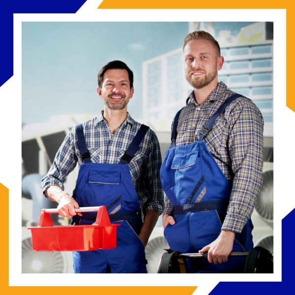 Two smiling male HVAC technicians in matching blue overalls and plaid shirts pose for the camera.