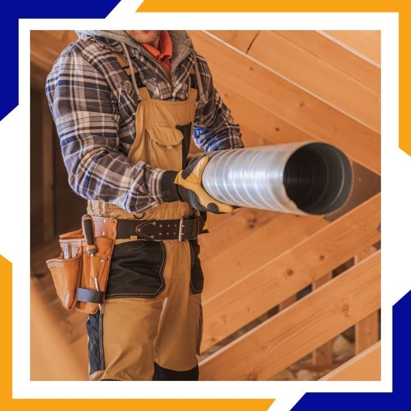 Heating Installation Greeley 2 A construction worker in overalls and a tool belt holds a section of flexible metal ducting.
