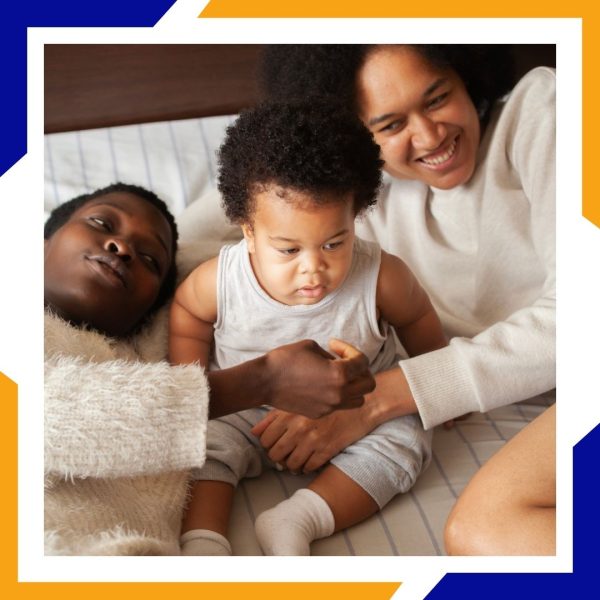 Heating Installation Loveland 4 A happy family with a baby sits together in a warm and comfortable bedroom.