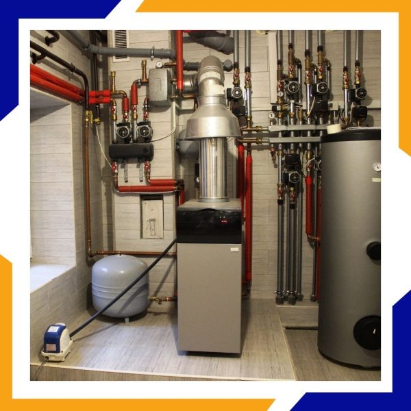 A complex boiler room with a furnace, water heater, and multiple pipes, showing a professional installation.