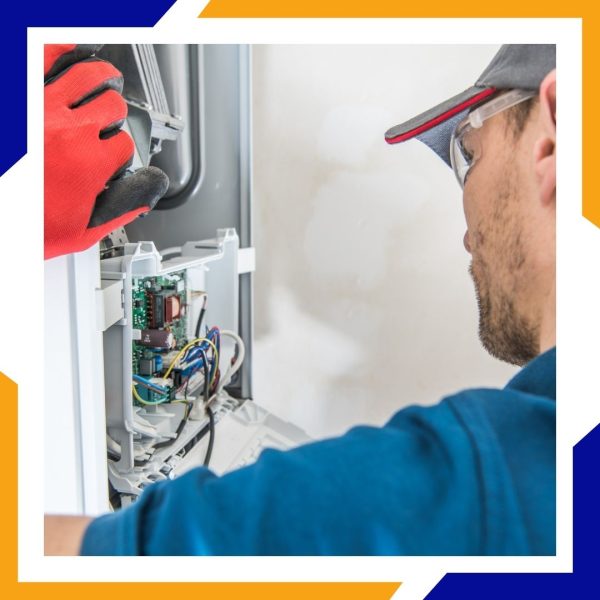 Heating Repair Brighton 1 A technician in safety glasses carefully inspects the circuit board and wiring of a heating unit.