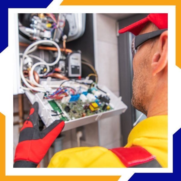 An HVAC technician in a red cap carefully removes the main circuit board from a boiler unit.