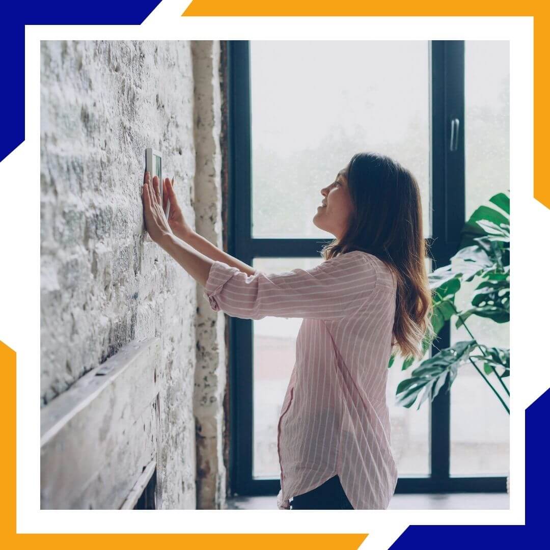 woman adjusting thermostat