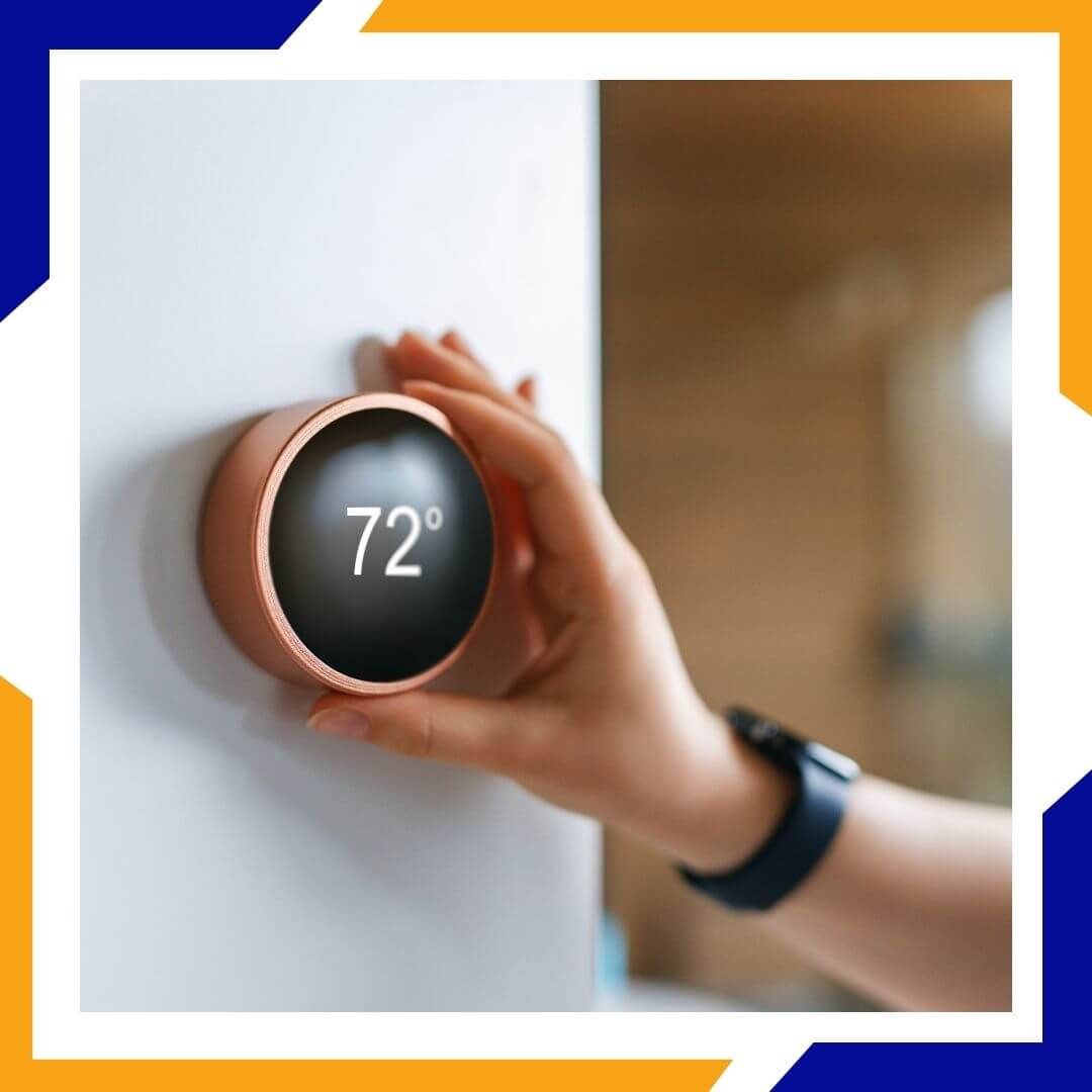person adjusting their thermostat